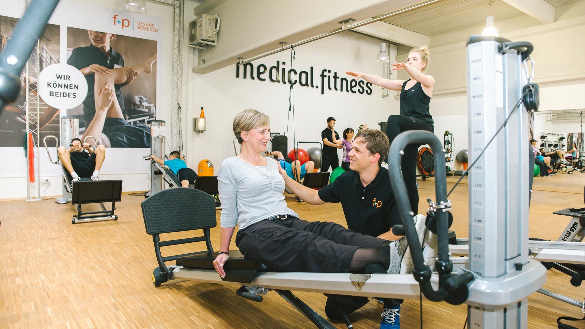 Rücken-Trainingssituation mit älterer Frau und jungem Trainer im Medical-Fitness Bereich des FitnessParks