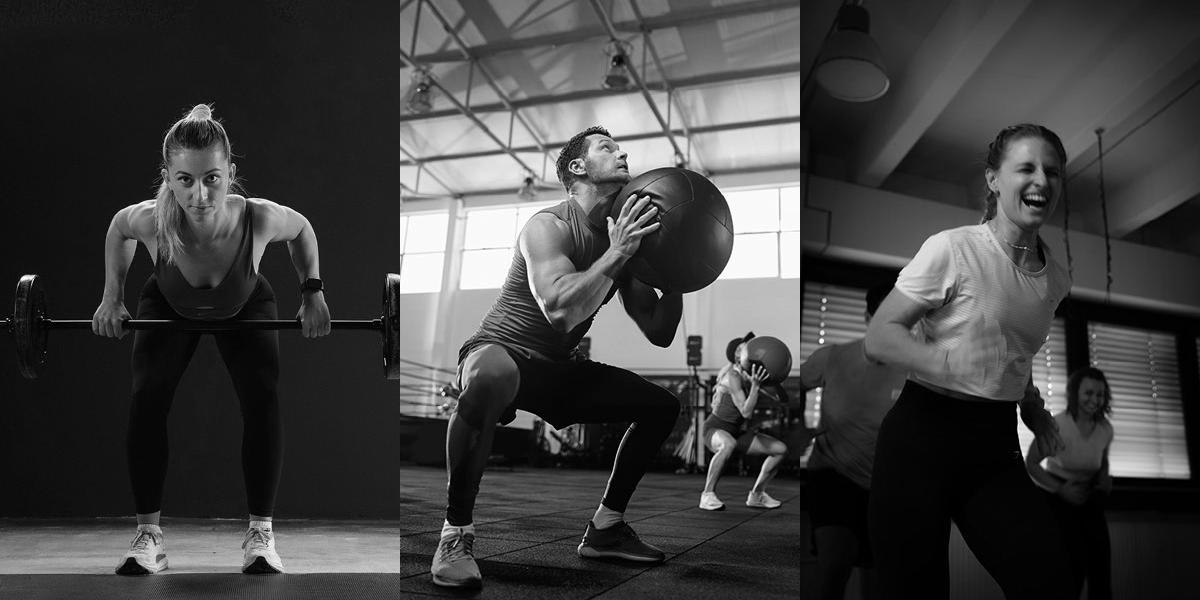 Mehrere Menschen trainieren mit Langhantel und Medizinbällen bei einem funktionellen Ganzkörpertraining im Fitnessstudio.