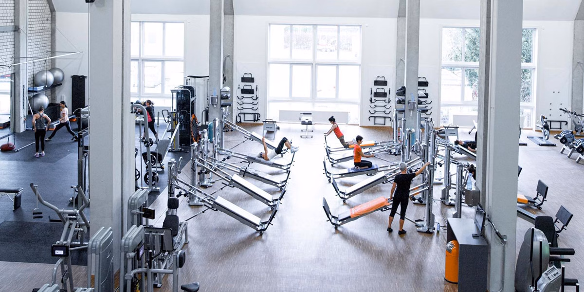 Helle, offene Trainingsfläche bei f+p Parks Kempten mit modernen Kraftgeräten und mehreren Personen beim Training